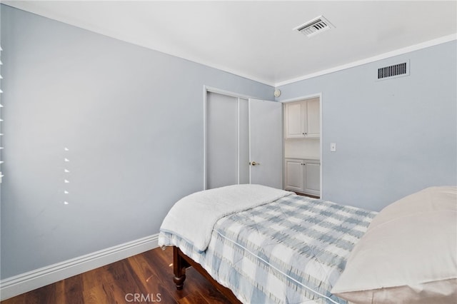 bedroom with baseboards, a closet, visible vents, and dark wood-type flooring