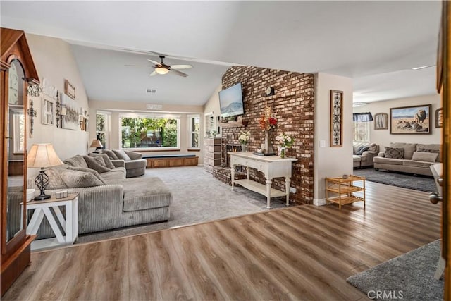 living area with lofted ceiling, ceiling fan, visible vents, and wood finished floors