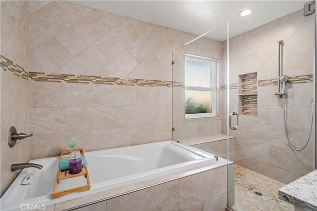 bathroom with a stall shower, tile walls, a bath, and recessed lighting