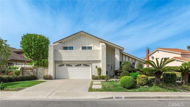 view of front of property featuring a garage, driveway, a gate, and stucco siding