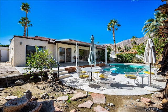 view of pool with fence, a mountain view, a fenced in pool, and a patio