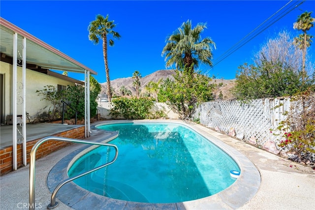 view of pool with a fenced backyard, a mountain view, and a fenced in pool