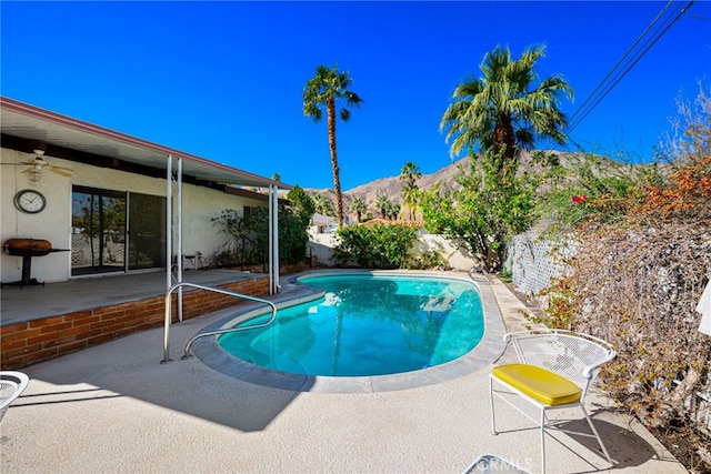 view of swimming pool featuring a fenced in pool, a fenced backyard, a mountain view, and a patio