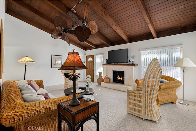 carpeted living area featuring vaulted ceiling with beams, wooden ceiling, ceiling fan, and a fireplace