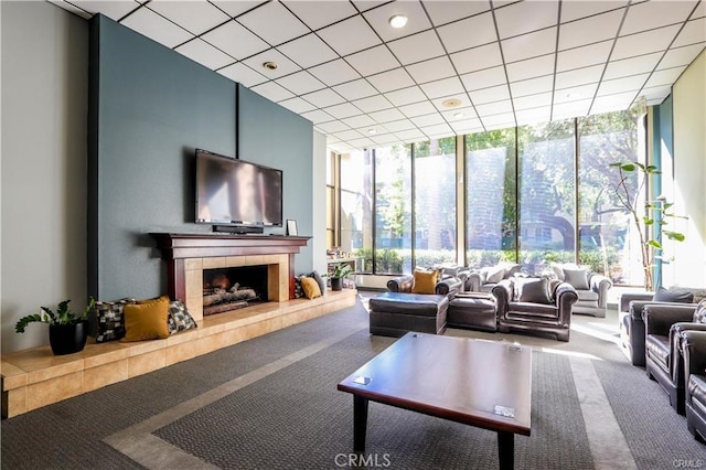 carpeted living room featuring a tile fireplace, a wealth of natural light, and floor to ceiling windows