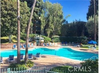 pool with a patio area and fence