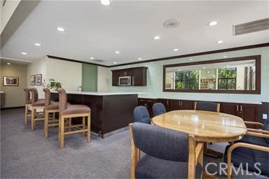 carpeted dining space with ornamental molding and recessed lighting