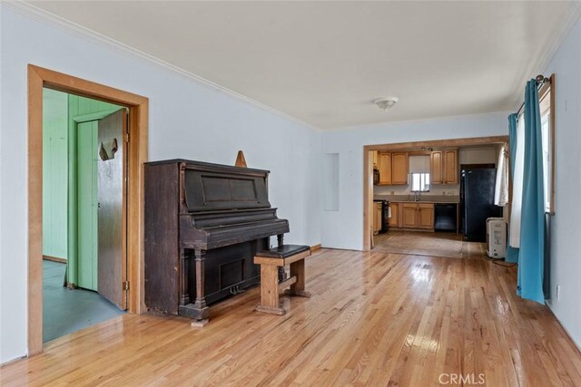living area with ornamental molding and light wood-type flooring