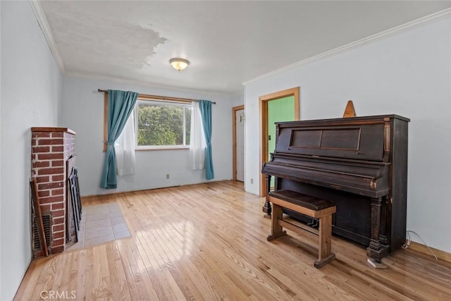 sitting room featuring ornamental molding, a fireplace, and light wood-style flooring