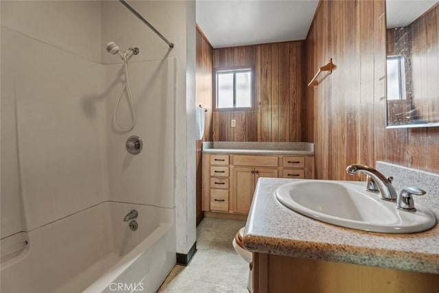 full bath with wood walls, vanity, toilet, and shower / washtub combination