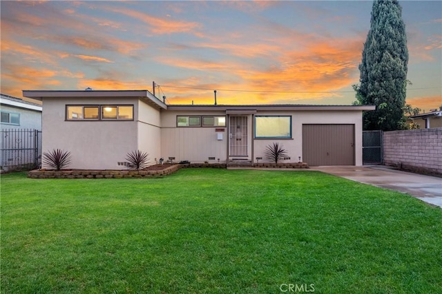 mid-century modern home featuring fence, concrete driveway, a yard, crawl space, and an attached garage