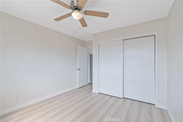 unfurnished bedroom featuring a closet, ceiling fan, baseboards, and light wood-style floors