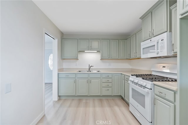 kitchen featuring a sink, white appliances, light wood-style floors, light countertops, and baseboards