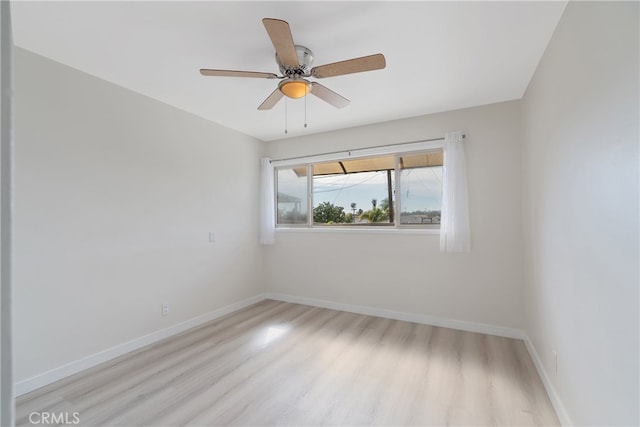 unfurnished room with a ceiling fan, wood finished floors, and baseboards