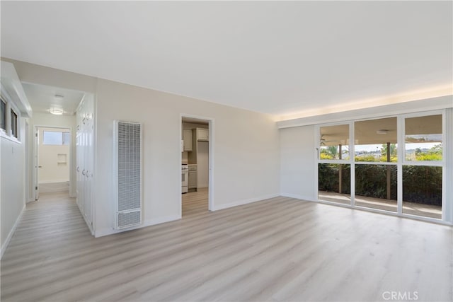 unfurnished room featuring baseboards, a healthy amount of sunlight, and light wood-style flooring