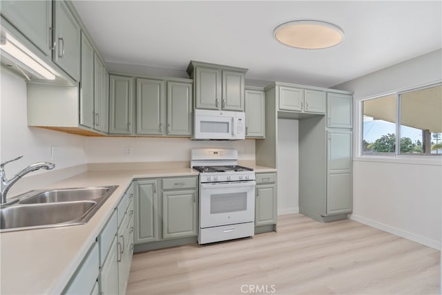 kitchen featuring light wood-style flooring, a sink, white appliances, light countertops, and baseboards