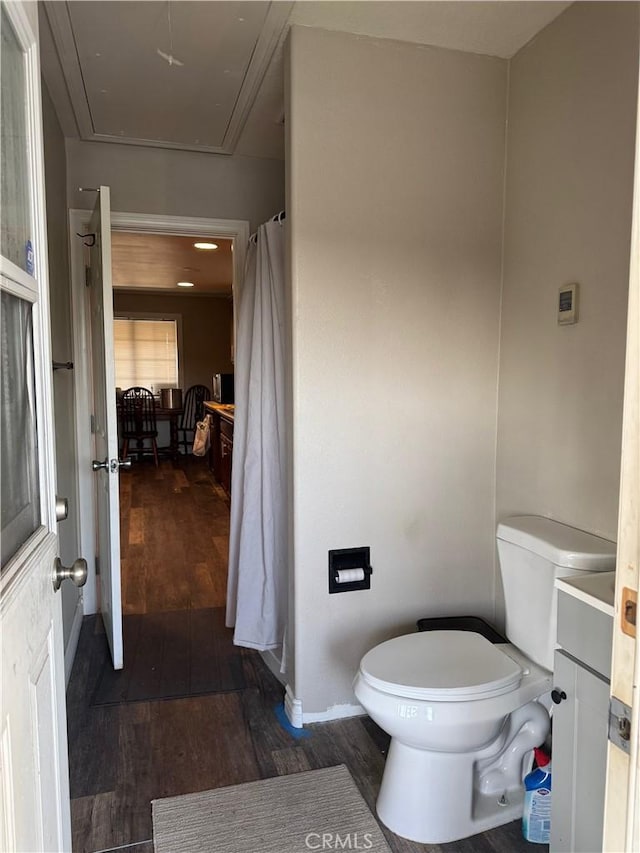 full bathroom with baseboards, toilet, and wood finished floors