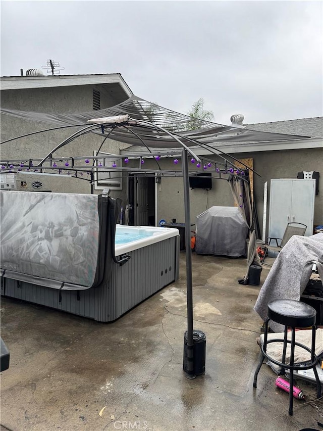 view of patio / terrace featuring a hot tub and grilling area