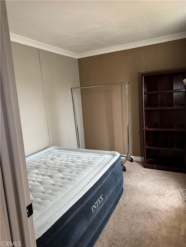 bedroom with carpet flooring, crown molding, a textured ceiling, and baseboards