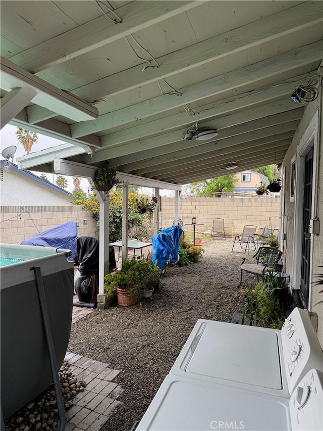 view of patio with washing machine and dryer and a fenced backyard