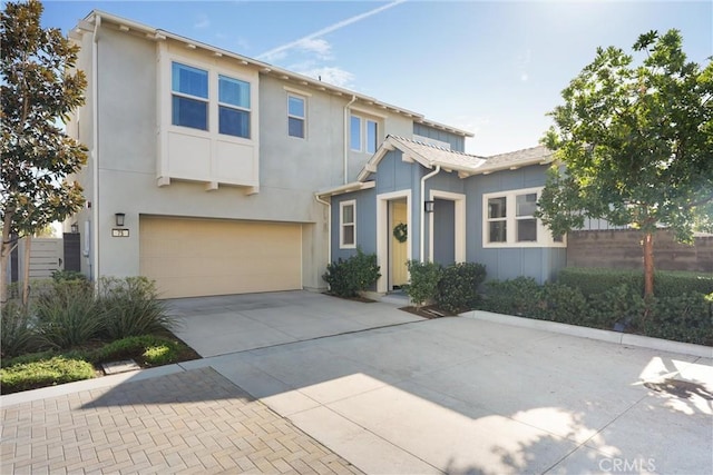 view of front of property with driveway, an attached garage, and stucco siding