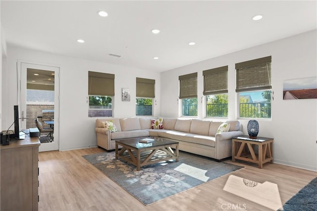 living room featuring light wood finished floors, baseboards, visible vents, and recessed lighting