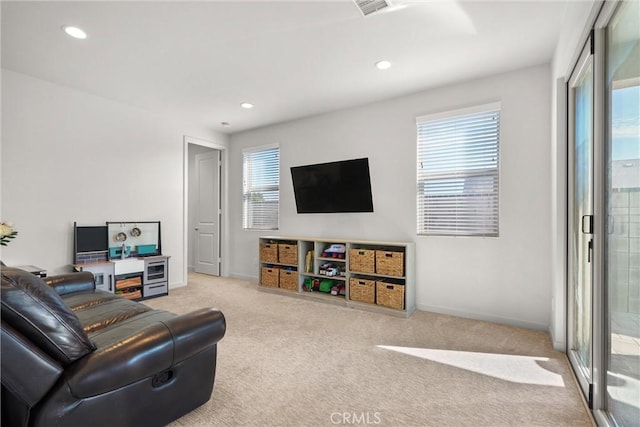 living area with recessed lighting, light carpet, and baseboards