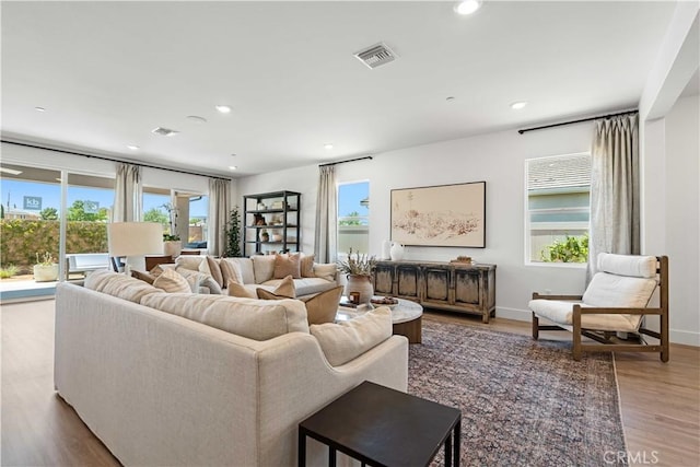 living area with a healthy amount of sunlight, light wood-style flooring, visible vents, and recessed lighting