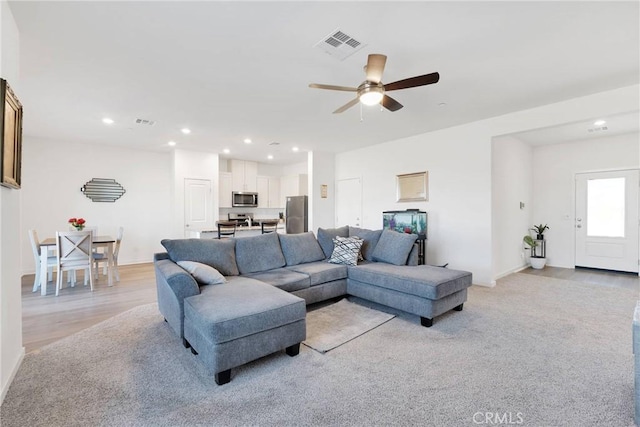 living room with a ceiling fan, recessed lighting, visible vents, and light wood-style flooring