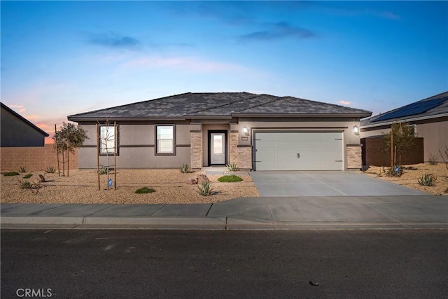 view of front facade featuring a garage, concrete driveway, fence, and stucco siding