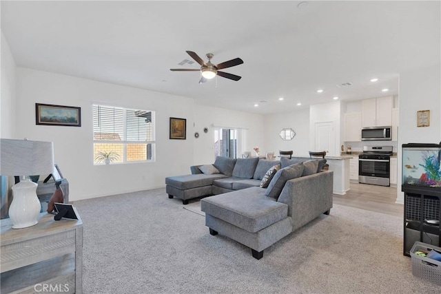 living room featuring recessed lighting, light carpet, and ceiling fan