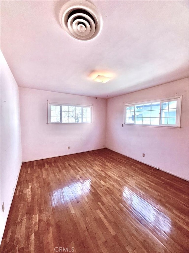 unfurnished room featuring plenty of natural light and hardwood / wood-style floors