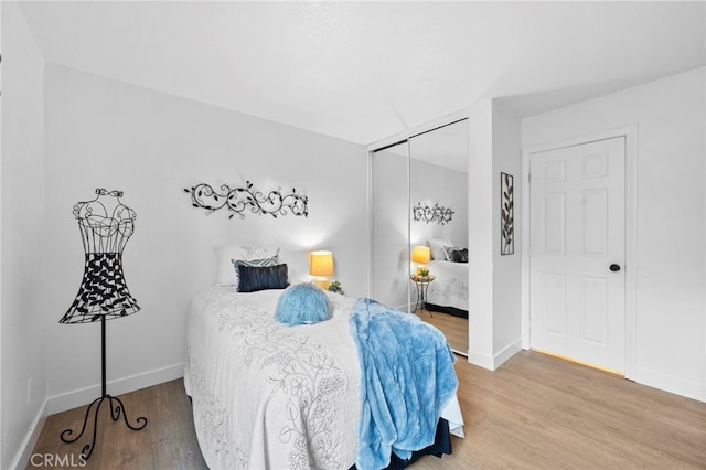 bedroom featuring a closet, wood finished floors, and baseboards