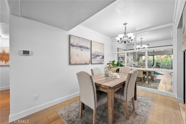 dining area with a chandelier, light wood finished floors, ornamental molding, and baseboards