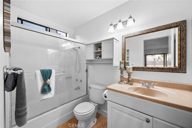 bathroom with combined bath / shower with glass door, vanity, toilet, and tile patterned floors