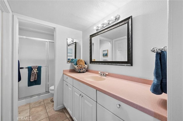 bathroom featuring toilet, tile patterned flooring, a textured ceiling, vanity, and a shower stall