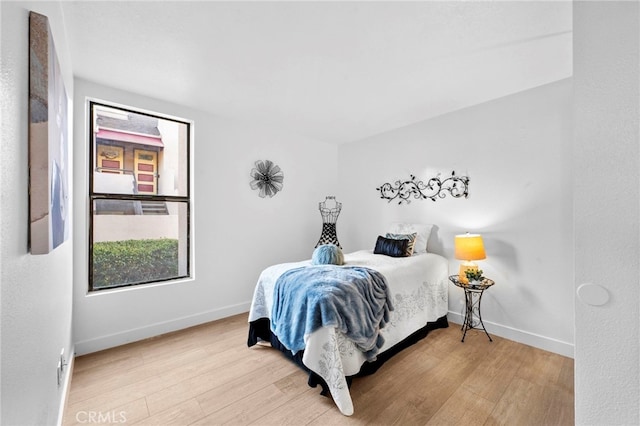 bedroom featuring light wood-style floors and baseboards