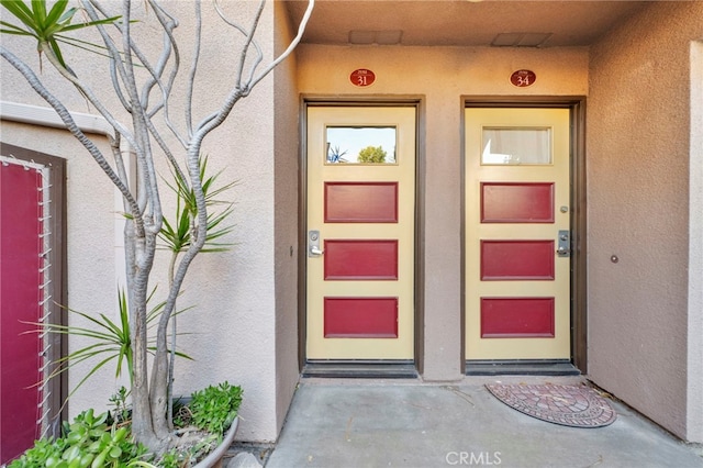 doorway to property featuring stucco siding