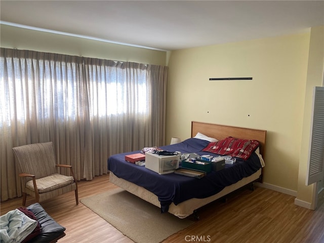 bedroom with baseboards and wood finished floors