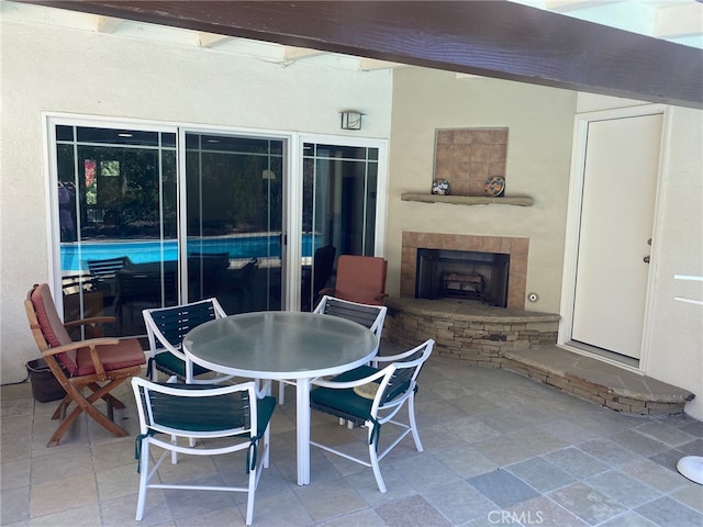 view of patio / terrace featuring outdoor dining space and a stone fireplace