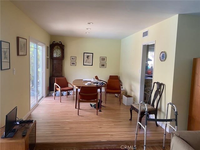 dining space with light wood-style floors and visible vents