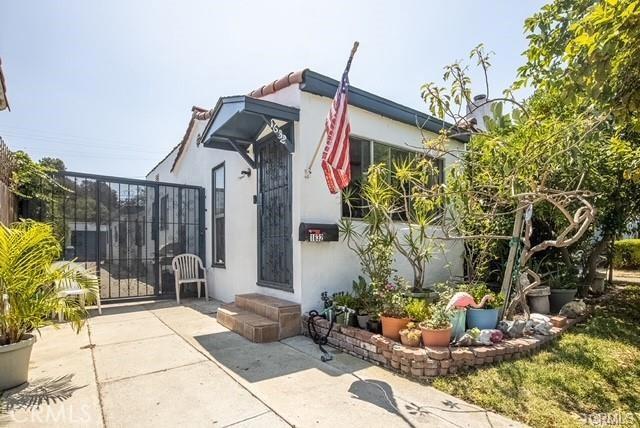 exterior space with a patio area, a gate, and stucco siding