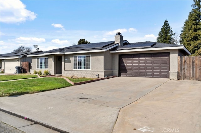 single story home featuring driveway, brick siding, an attached garage, and roof mounted solar panels