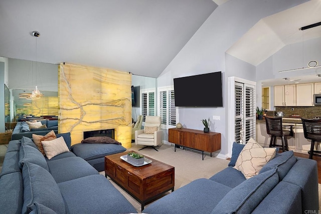 living area featuring high vaulted ceiling and light carpet