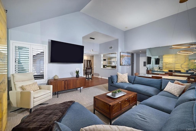 living room with high vaulted ceiling, a chandelier, and visible vents