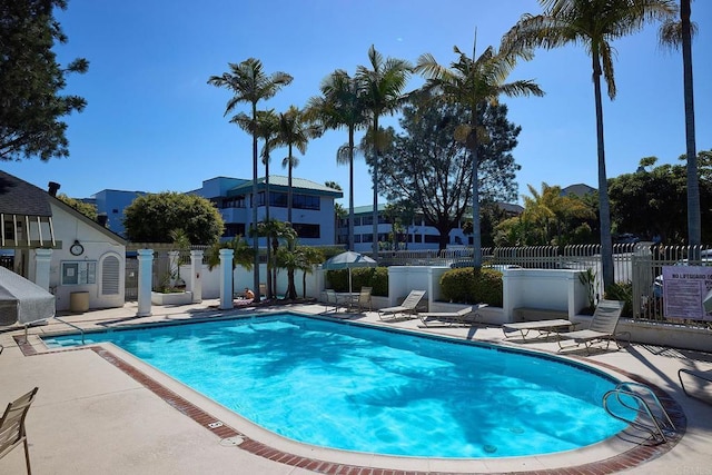 community pool featuring a patio and fence