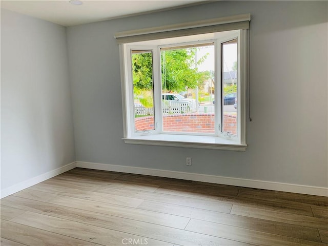 empty room featuring baseboards and wood finished floors