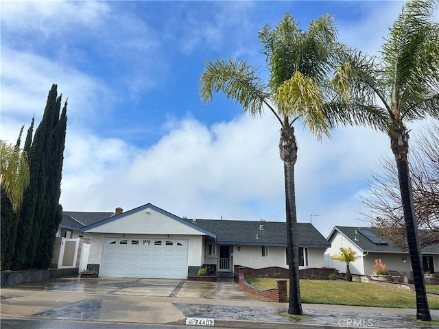 ranch-style home with stucco siding, a front lawn, concrete driveway, and an attached garage