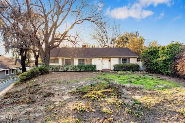 ranch-style home with a chimney