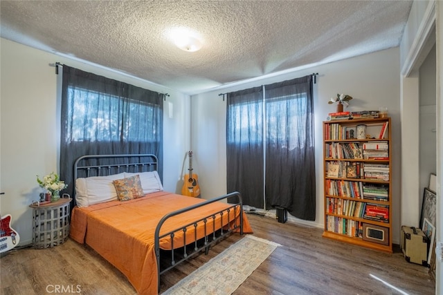 bedroom featuring a textured ceiling and wood finished floors